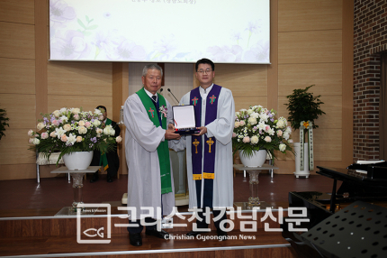 무안교회 김정수 위임목사가 목사위임패를 받는 모습.