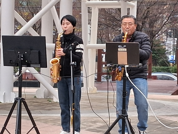 상남분수광장에서 색소폰연주하는 김성현 장로(우)와 박옥희 집사(좌).