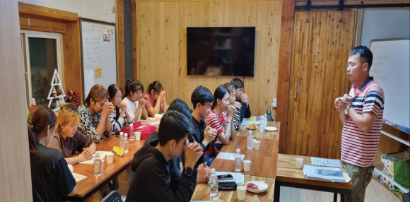 이주민들과 함께 기도하고 있는 모습