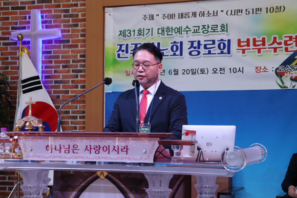회록서기 유동훈 장로가 성경봉독을 하고 있다.