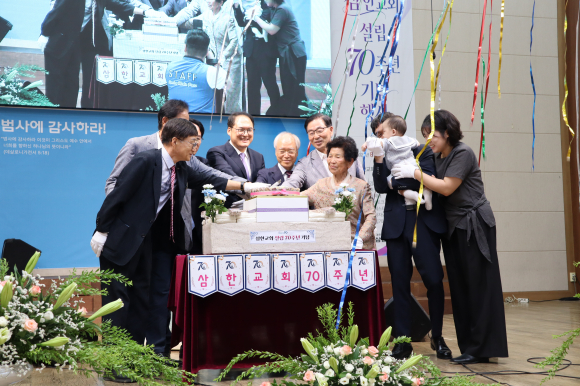 삼한교회 설립 70주년 기념행사에서 주요 내빈과 당회원, 최연소 교인부터 94세 어르신에 이르기까지 전 세대 대표들이 함께 축하 케이크를 커팅하고 있다.