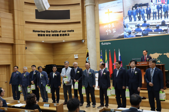 전 회장을 소개하고 선물을 건네받고 있는 모습