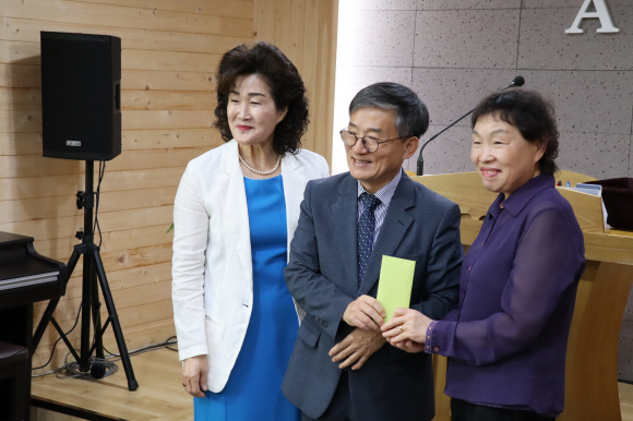 여전도회장이 대표로 선한목자교회에 5개월치 임대료를 지원하고 기념사진을 찍고 있다.